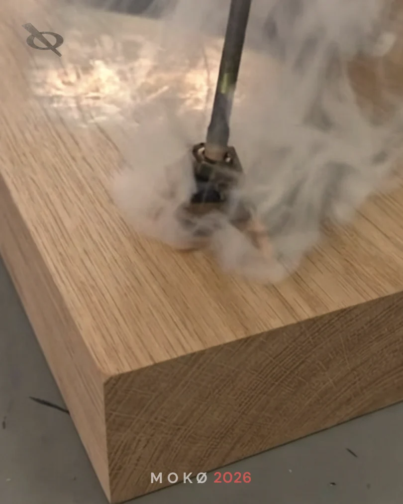 Tool working over a natural wood panel during a finishing process